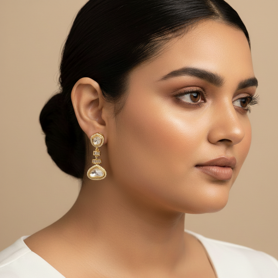 Woman wearing gold earrings against a beige background