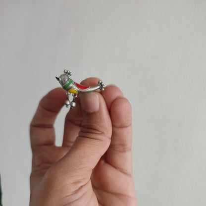 Hand holding a small decorative item against a plain background