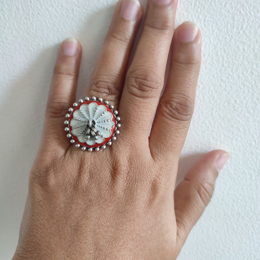 Hand wearing a decorative ring on a white background
