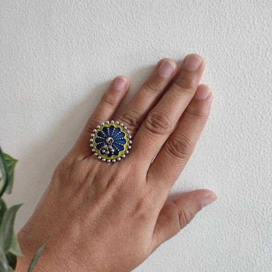 Hand wearing a decorative ring on a white background