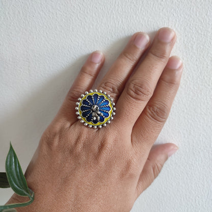 Hand wearing a decorative ring on a white background