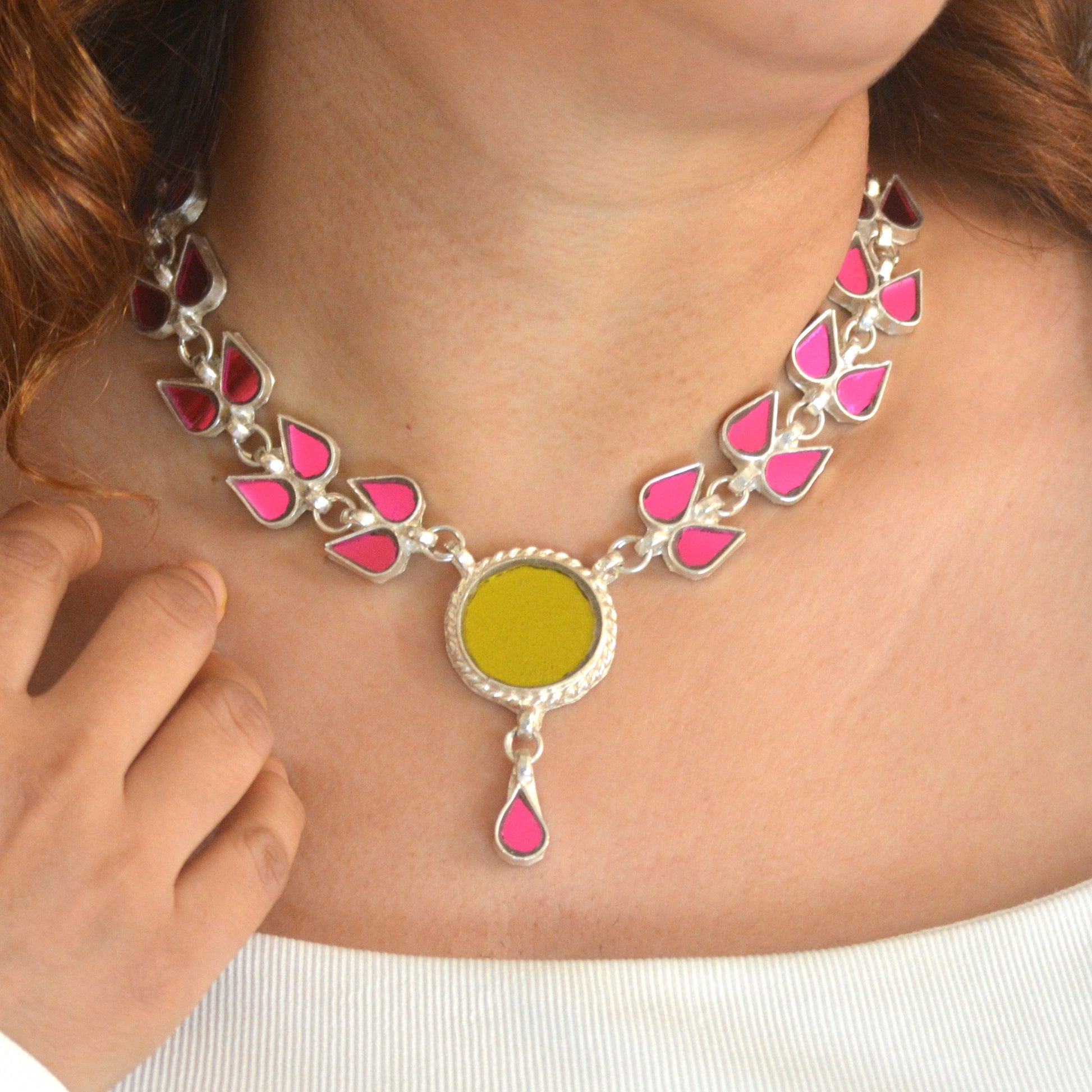 Necklace with pink and yellow pendant worn by a person
