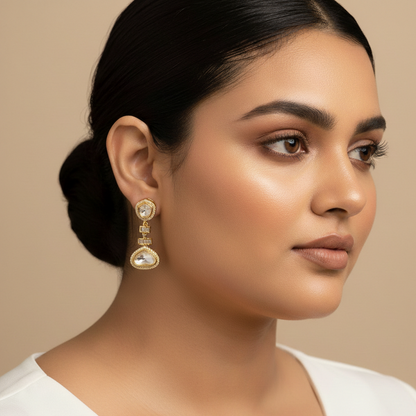 Woman wearing gold earrings against a beige background